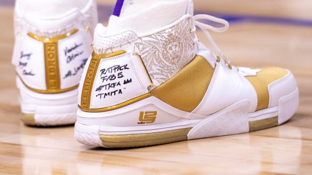 View of white and gold Nike LeBron shoes.